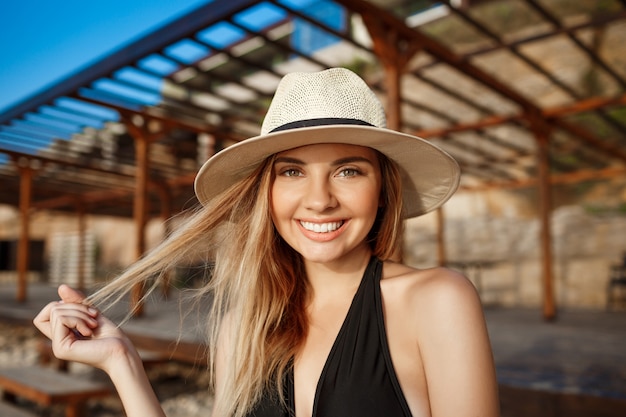 La bella giovane ragazza allegra riposa alla spiaggia di mattina