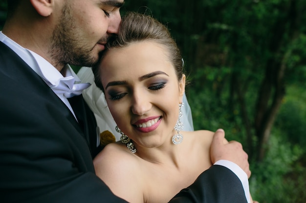 Beautiful young couple posing in the forest from close angle