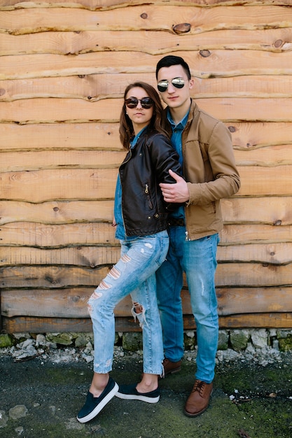 Beautiful young couple posing over wooden wall