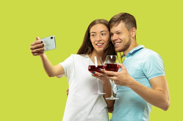 Beautiful young couple's half-length portrait isolated on green