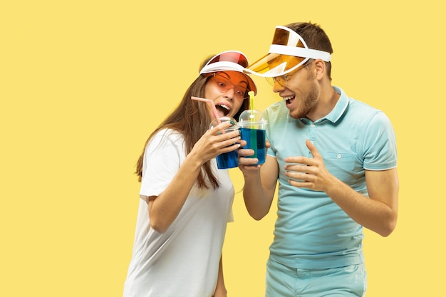 Beautiful young couple's half-length portrait isolated on yellow