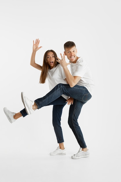 Бесплатное фото Портрет красивой молодой пары изолированный на белой стене. выражение лица, человеческие эмоции, рекламная концепция. copyspace. женщина и мужчина прыгают, танцуют или бегают вместе.