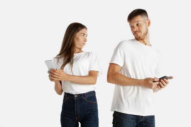 Beautiful young couple's portrait isolated on white  space. Facial expression, human emotions, advertising concept.