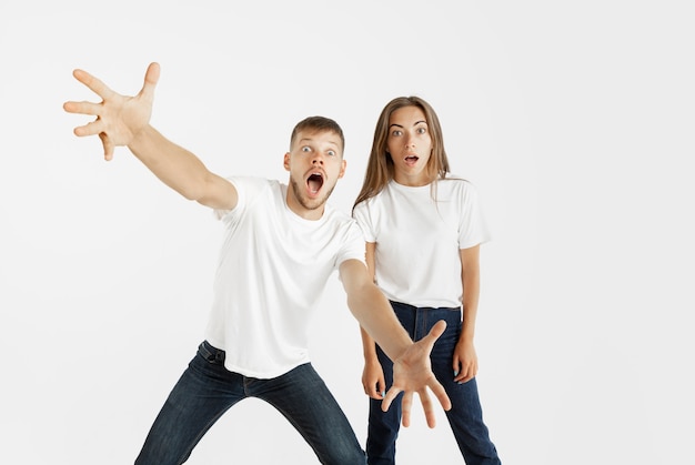 Free photo beautiful young couple's portrait isolated on white studio background. facial expression, human emotions, advertising concept. copyspace. woman and man look shocked, astonished and wondered.