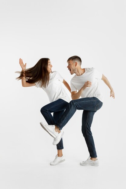 Beautiful young couple's portrait isolated on white studio wall