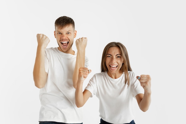 Beautiful young couple's portrait isolated on white studio wall