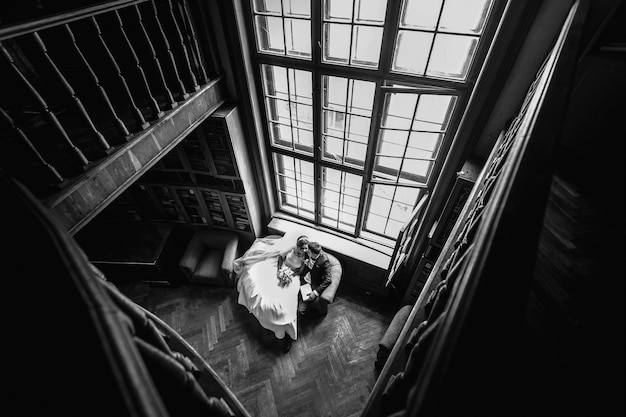 Free photo beautiful and young couple sitting together on the couch in the old room