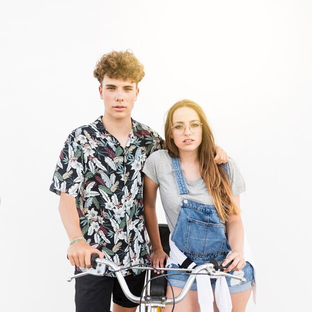 Beautiful young couple with bicycle on white backdrop