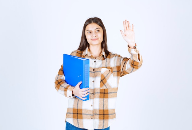 Beautiful young employee with blue folder posing . 