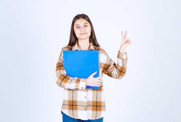 Beautiful young employee with blue folder posing . 