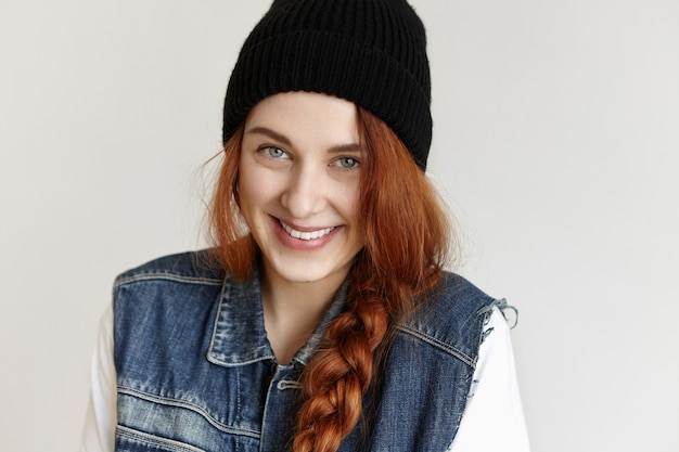 Beautiful young European female student with charismatic smile wearing her ginger hair in messy ponytail