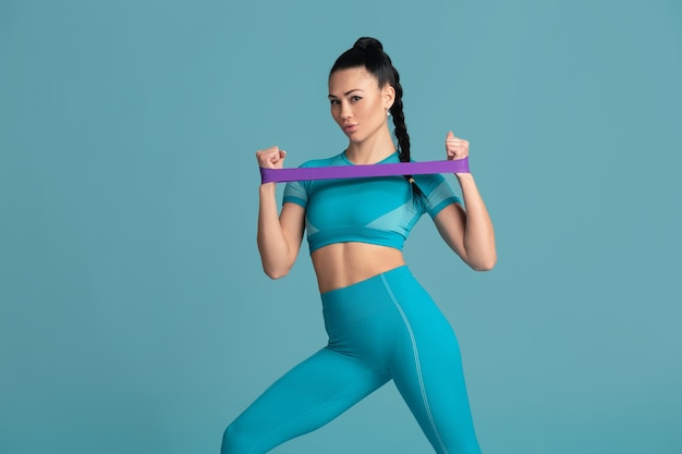 Beautiful young female athlete practicing in studio