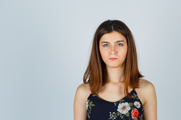 Beautiful young female in blouse and looking frustrated