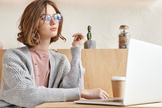 Bella giovane femmina che lavora con il computer portatile