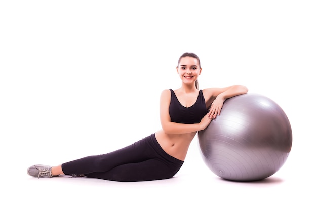 Красивая молодая женщина фитнеса с гимнастическим мячом упражнения, изолированные на белом фоне