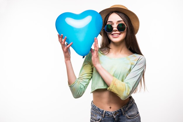 Beautiful young girl holding a blue heart air balloon. The concept of Valentine's Day