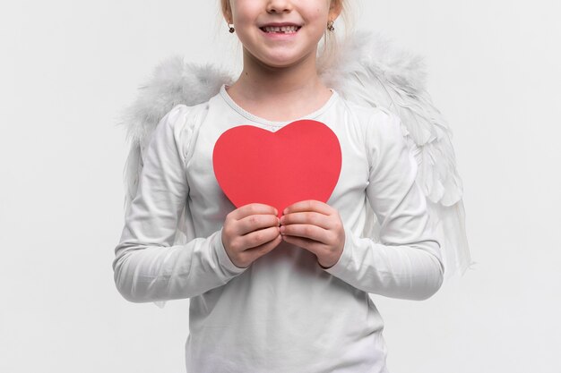 Beautiful young girl holding a heart