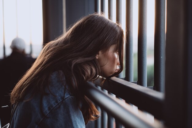 Beautiful young girl portrait behind an iron fence