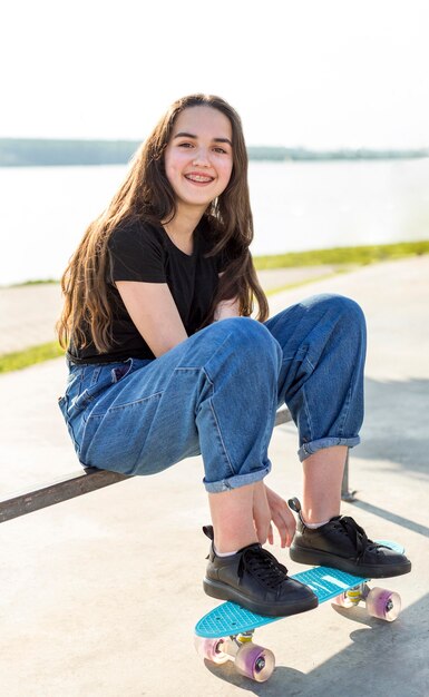 Beautiful young girl posing with her skateboard