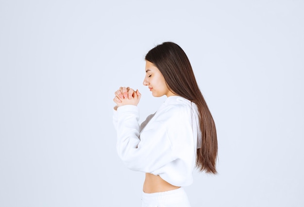 beautiful young girl praying with hands together.