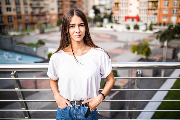 Bella ragazza per le strade della città moderna con gli occhiali. tempo libero, bellezza, concetto di moda