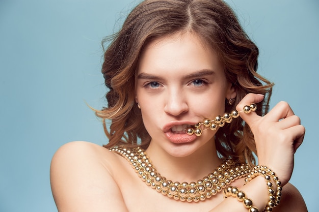 Beautiful young girl in studio with pearl jewelry