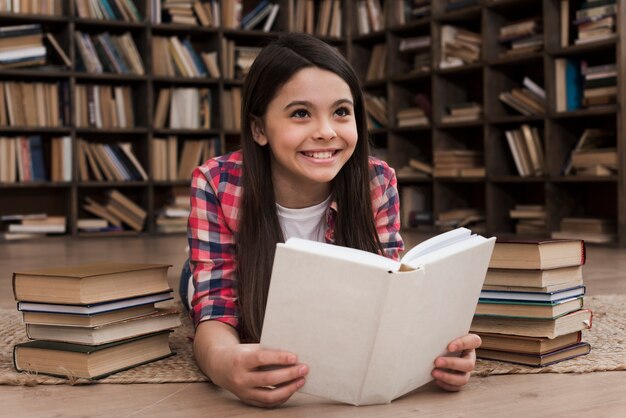 Красивая молодая девушка учится в библиотеке