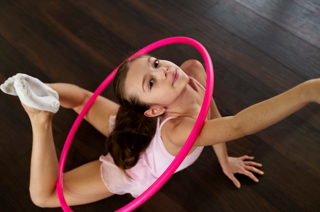 Free photo beautiful young girl using hula hop