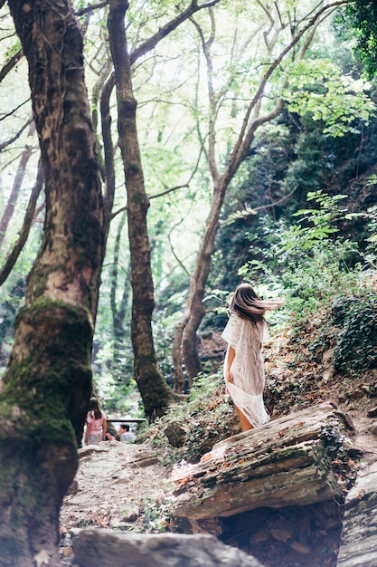 Beautiful, young girl walks at the foot of the mountain along