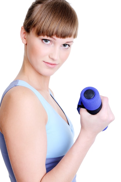 Free photo beautiful young girl with dumbbell looking at camera