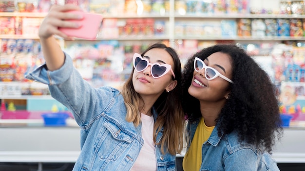 Free photo beautiful young girls taking a selfie together