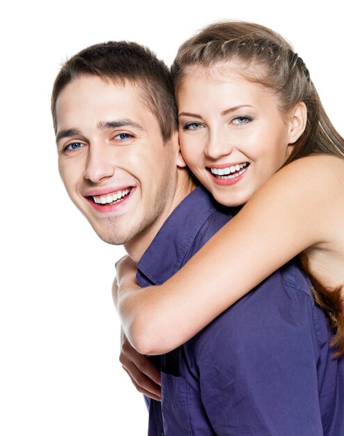 Beautiful young happy couple on white wall
