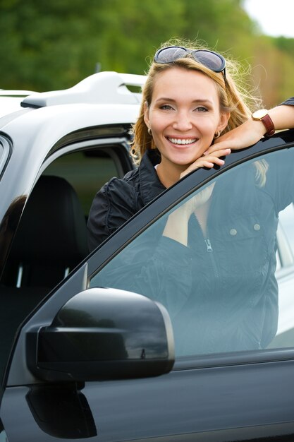 Beautiful young happy woman in the new car  - outdoors