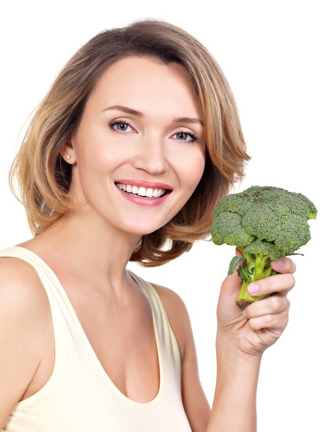 Beautiful young healthy woman holds broccoli isolated on white.