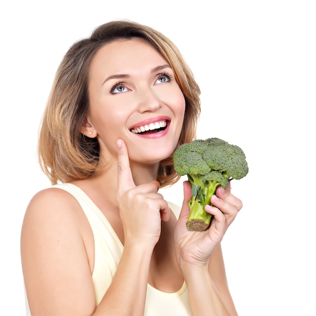 Foto gratuita la bella giovane donna in buona salute tiene i broccoli isolati su bianco.