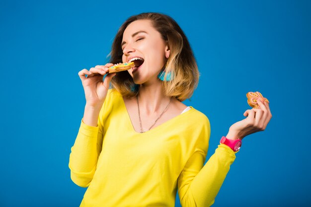 クッキーを食べて美しい若い流行に敏感な女性