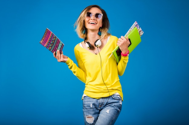 Beautiful young hipster woman holding books