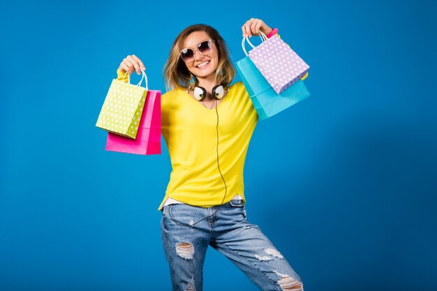다채로운 종이 쇼핑백을 들고 아름 다운 젊은 hipster 여자