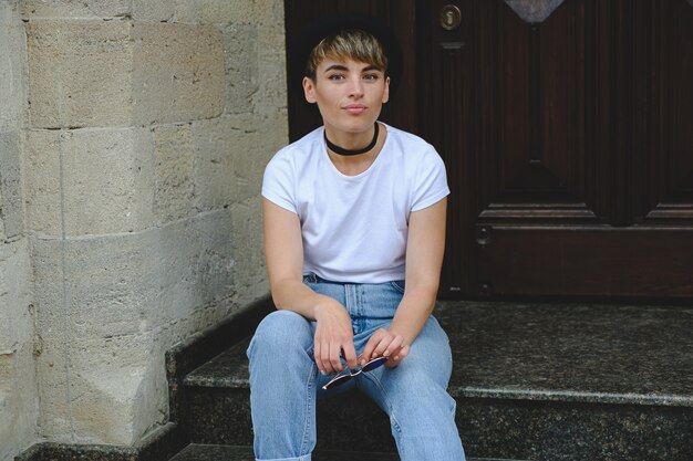 Beautiful young hipster woman posing sitting on stairs