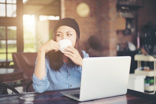 コーヒーショップに座って美しい若い流行に敏感な女性、リラックス