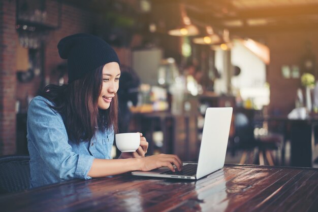 Beautiful young hipster woman sitting in a coffee shop, relax an