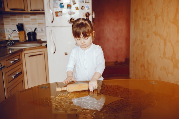 Una bella e giovane figlia sta cucinando in cucina a casa