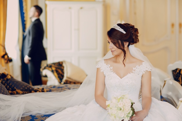 A beautiful young man wearing a black suit standing along with his bride