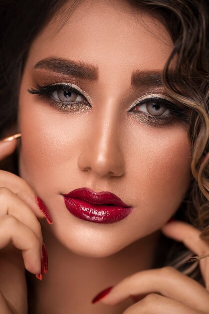 Beautiful young model with red lips and french manicure.