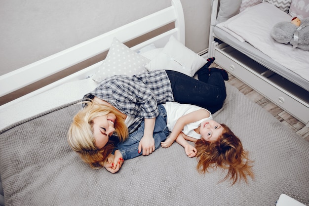 A beautiful young mother with her little daughter playing at home