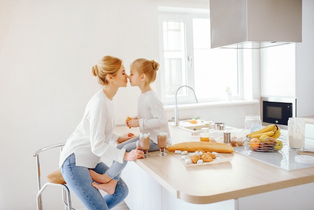 a beautiful young mother with light hair in white lace and blue jeans trousers sitting at home