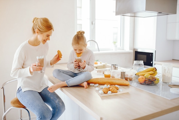 a beautiful young mother with light hair in white lace and blue jeans trousers sitting at home