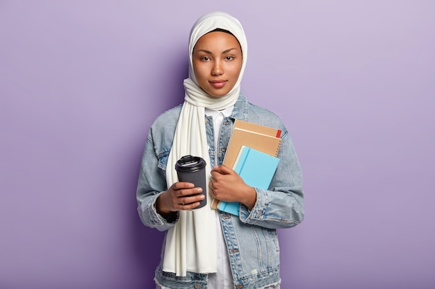 Bella giovane donna musulmana in posa con il suo telefono