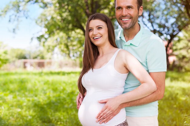 Beautiful young pregnant couple in nature
