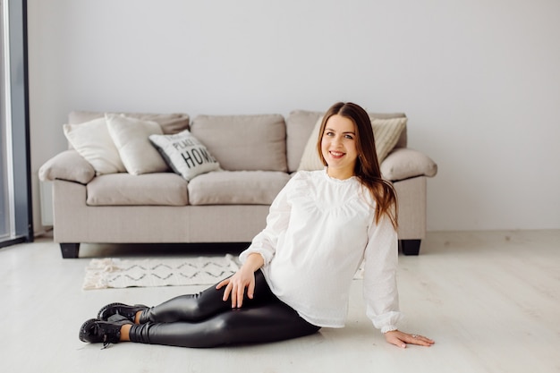 Beautiful young pregnant woman posing in dress